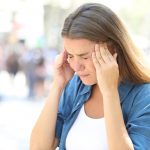 Girl suffering migraine in the street